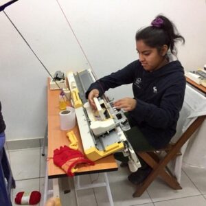 girl on knitting machine in Lima
